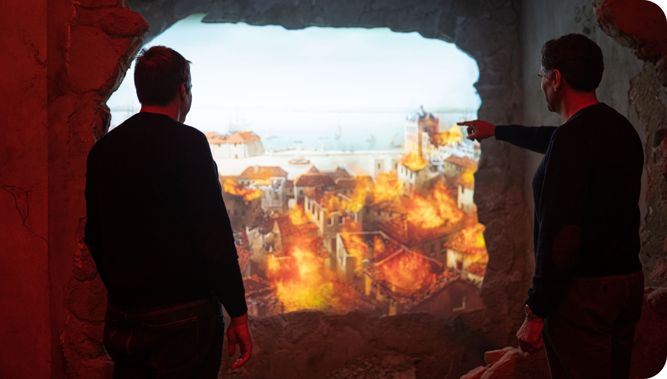 Two men looking at a video during Quake's museum visit