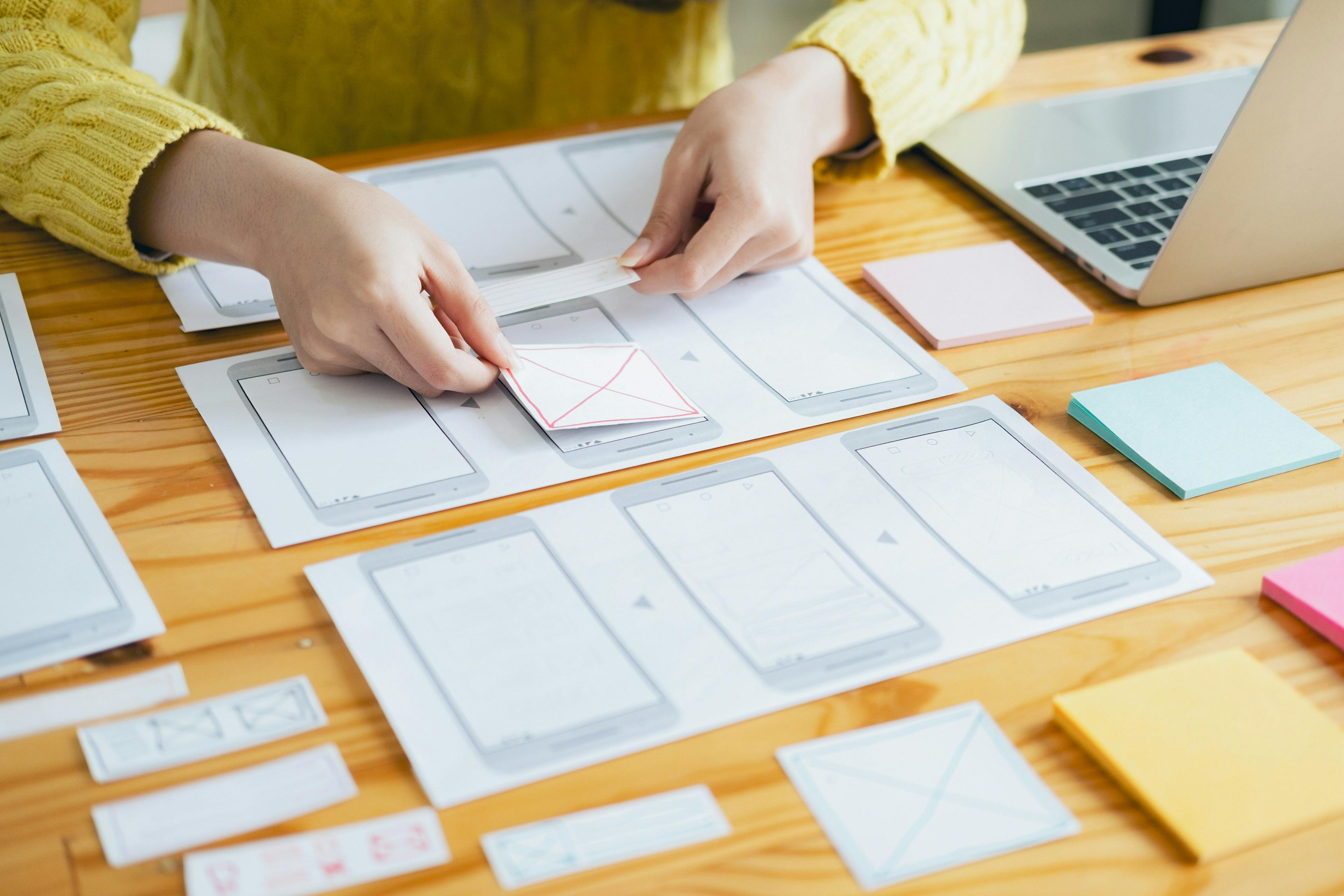 Women working on paper cellphone mockups