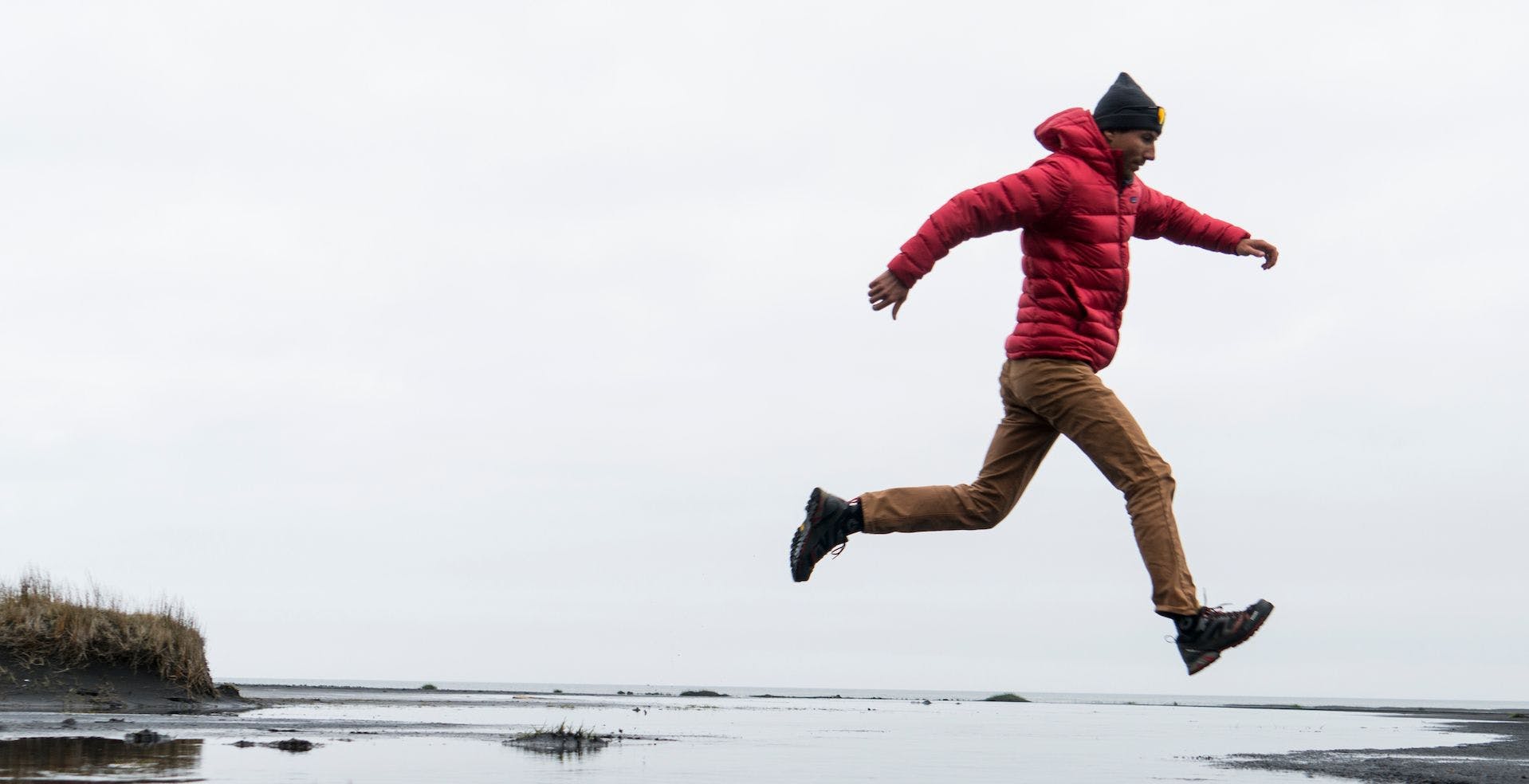 Men with jacket jumping on beach