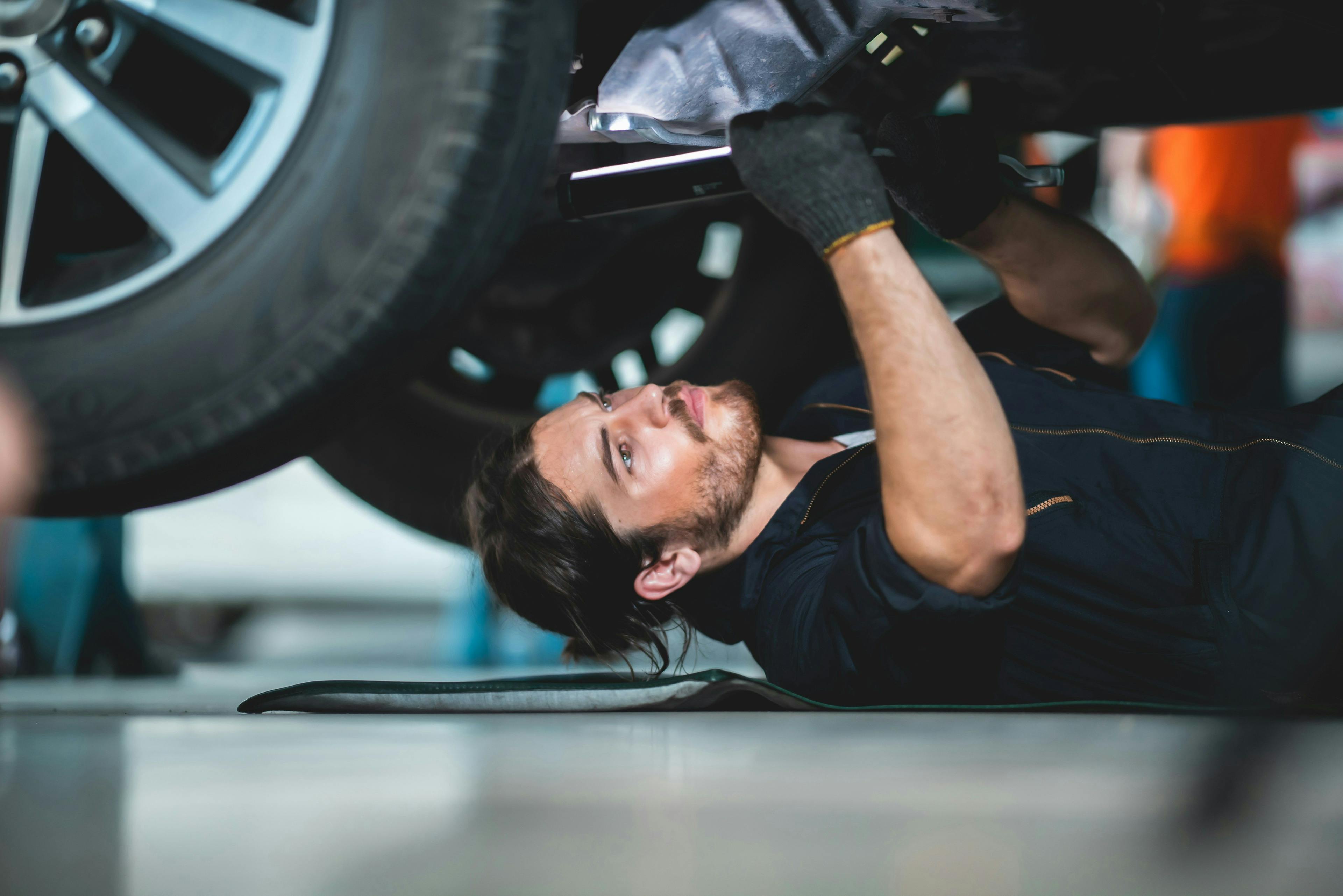 Mechanic bellow a car fixing it